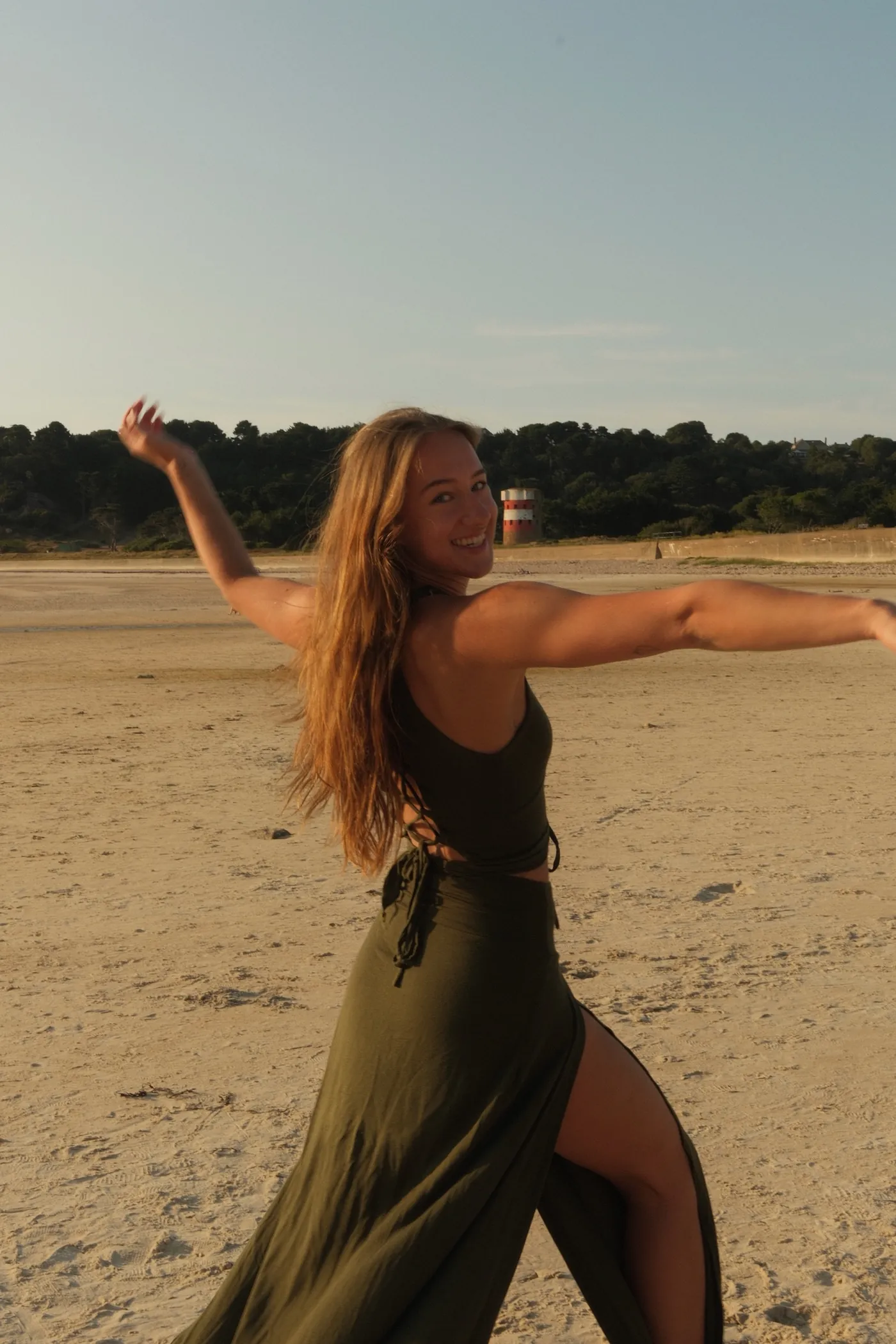 Naomi dancing on the beach at golden hour